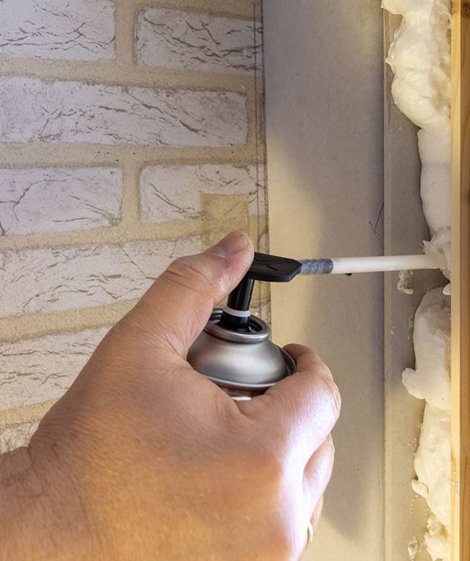 hand applying door insulation form